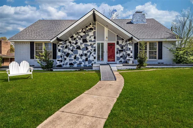a front view of a house with a yard garden and outdoor seating