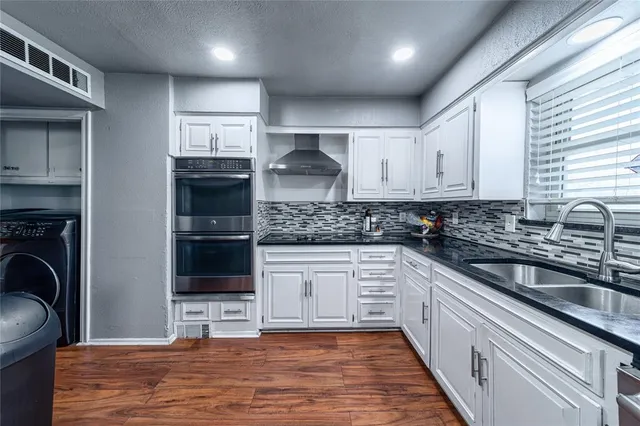 a kitchen with kitchen island granite countertop a sink cabinets and stainless steel appliances