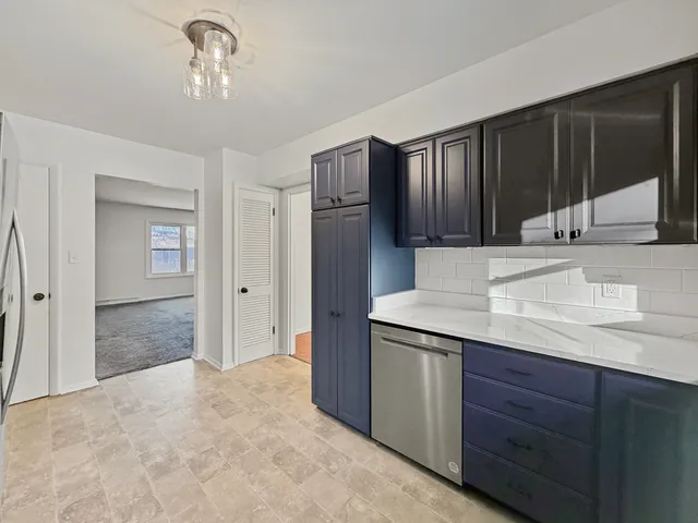 a kitchen with kitchen island granite countertop wooden cabinets and refrigerator