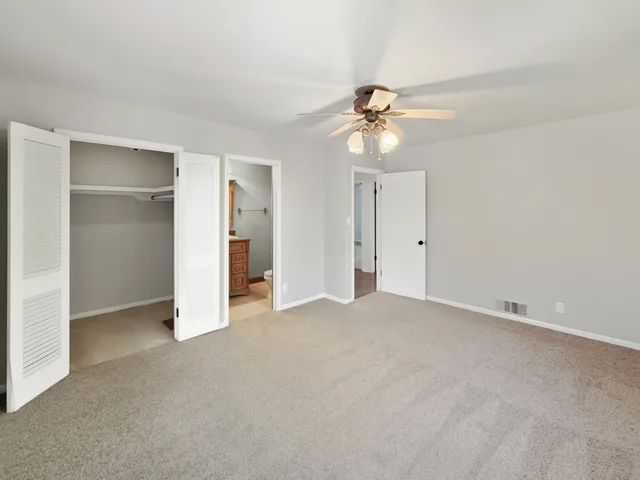 a view of an empty room with a ceiling fan