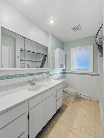 a bathroom with a toilet sink and mirror