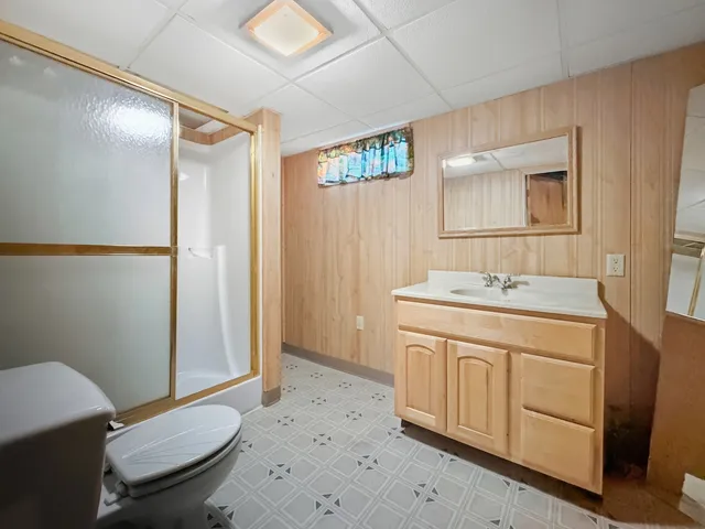 a spacious bathroom with a sink a toilet a mirror and shower