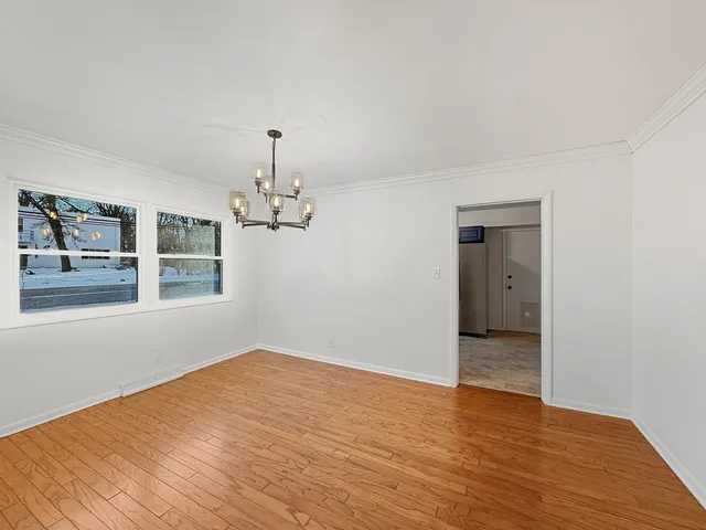 a view of empty room with wooden floor and window