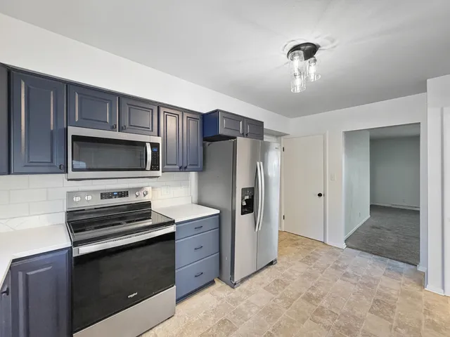 a kitchen with stainless steel appliances a stove a refrigerator and a sink