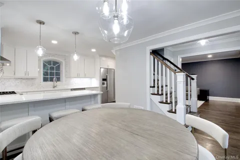 a large white kitchen with a large island oven a sink stainless steel appliances and cabinets