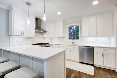 a kitchen with a white stove top oven and white cabinets