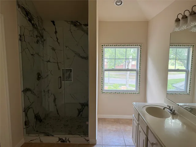 a bathroom with a granite countertop sink a toilet and shower