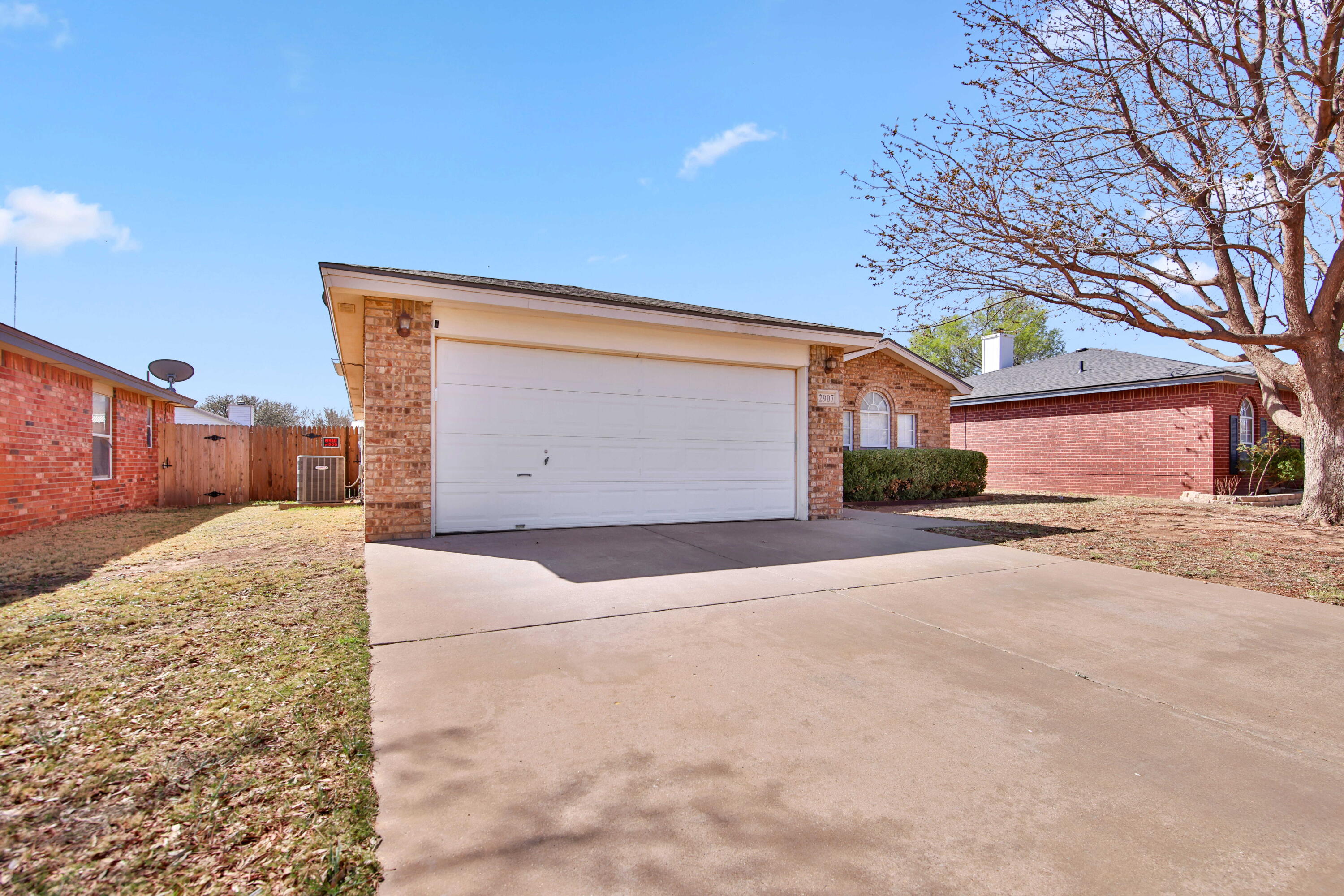 2907 90th Street Lubbock, TX 79423 - Photo 3 of 30 a front view of a house with a yard and garage