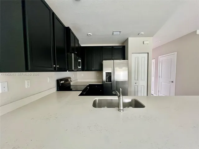 a kitchen with a refrigerator a stove and a sink