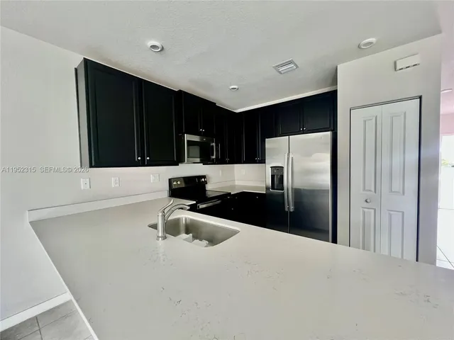 a kitchen with granite countertop a refrigerator and a sink