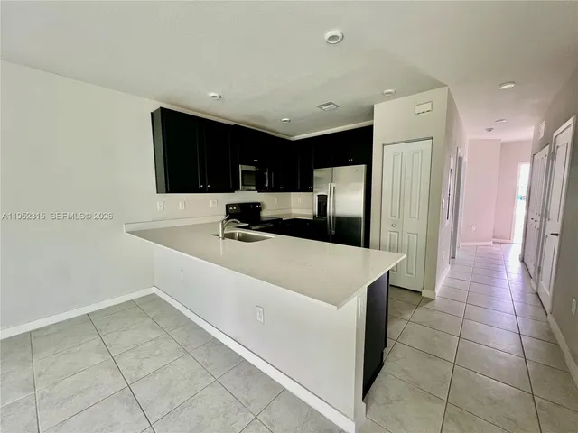 a kitchen with stainless steel appliances a refrigerator sink and cabinets