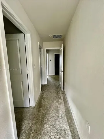 a view of a hallway with a wooden door