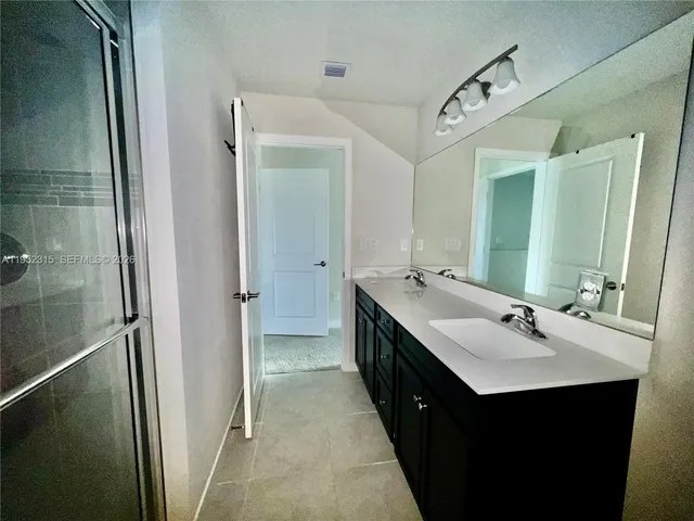 a bathroom with a double vanity sink and mirror