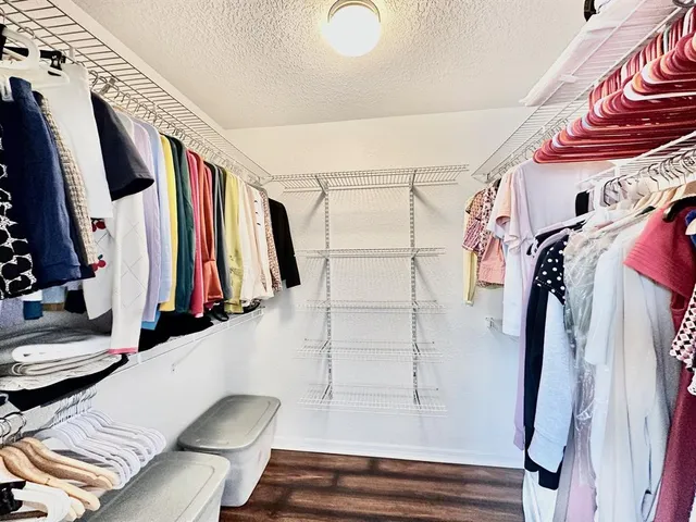 a view of walk in closet with clothes and shoes