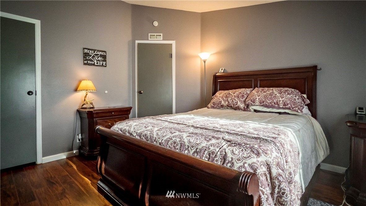 291 Spencer Road Sequim, WA 98382 - Photo 12 of 24 a bedroom with a bed and wooden floor