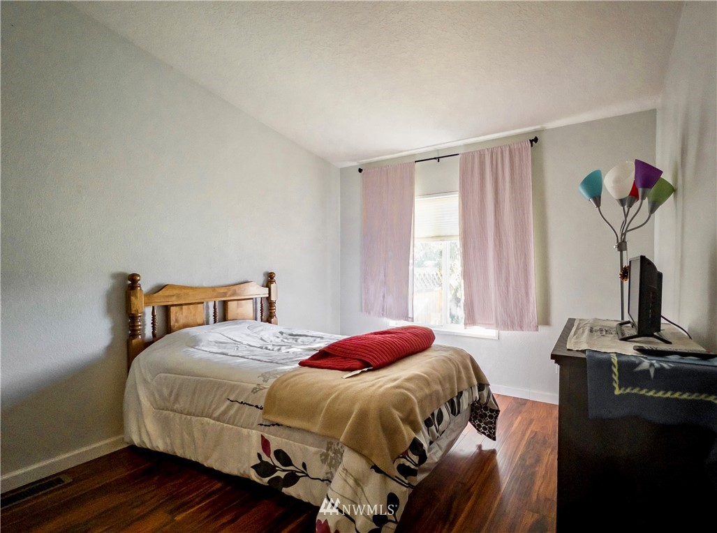291 Spencer Road Sequim, WA 98382 - Photo 16 of 24 a bedroom with a bed and wooden floor