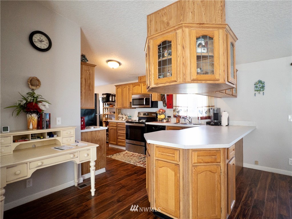 291 Spencer Road Sequim, WA 98382 - Photo 8 of 24 a kitchen with stainless steel appliances granite countertop a sink dishwasher and a stove with wooden floor