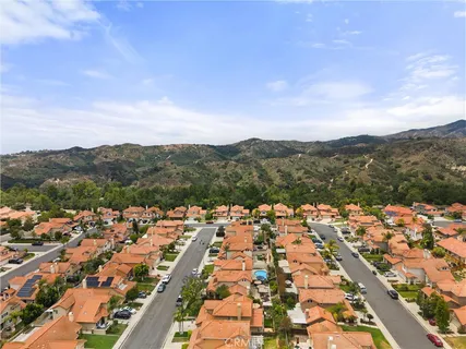 an aerial view of residential houses with outdoor space and trees