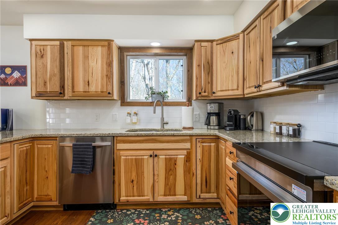 2206 Chatham Court Bushkill, PA 18324 - Photo 24 of 45 a kitchen with stainless steel appliances granite countertop a sink a stove and cabinets