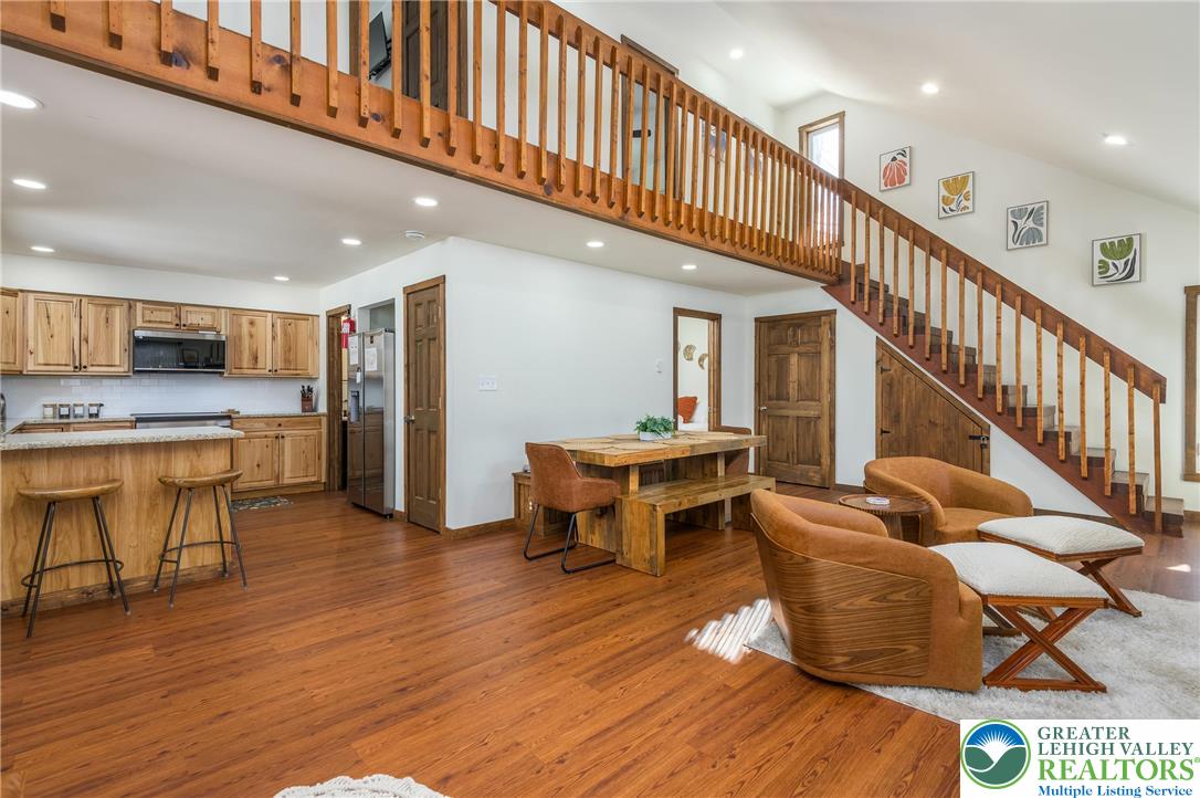 2206 Chatham Court Bushkill, PA 18324 - Photo 4 of 45 a living room with stainless steel appliances kitchen island granite countertop wooden floor a dining table and chairs