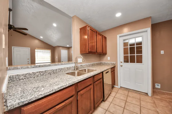 a kitchen with stainless steel appliances granite countertop a stove a sink and a microwave