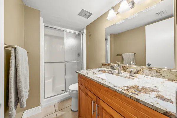 a bathroom with a granite countertop sink toilet and shower