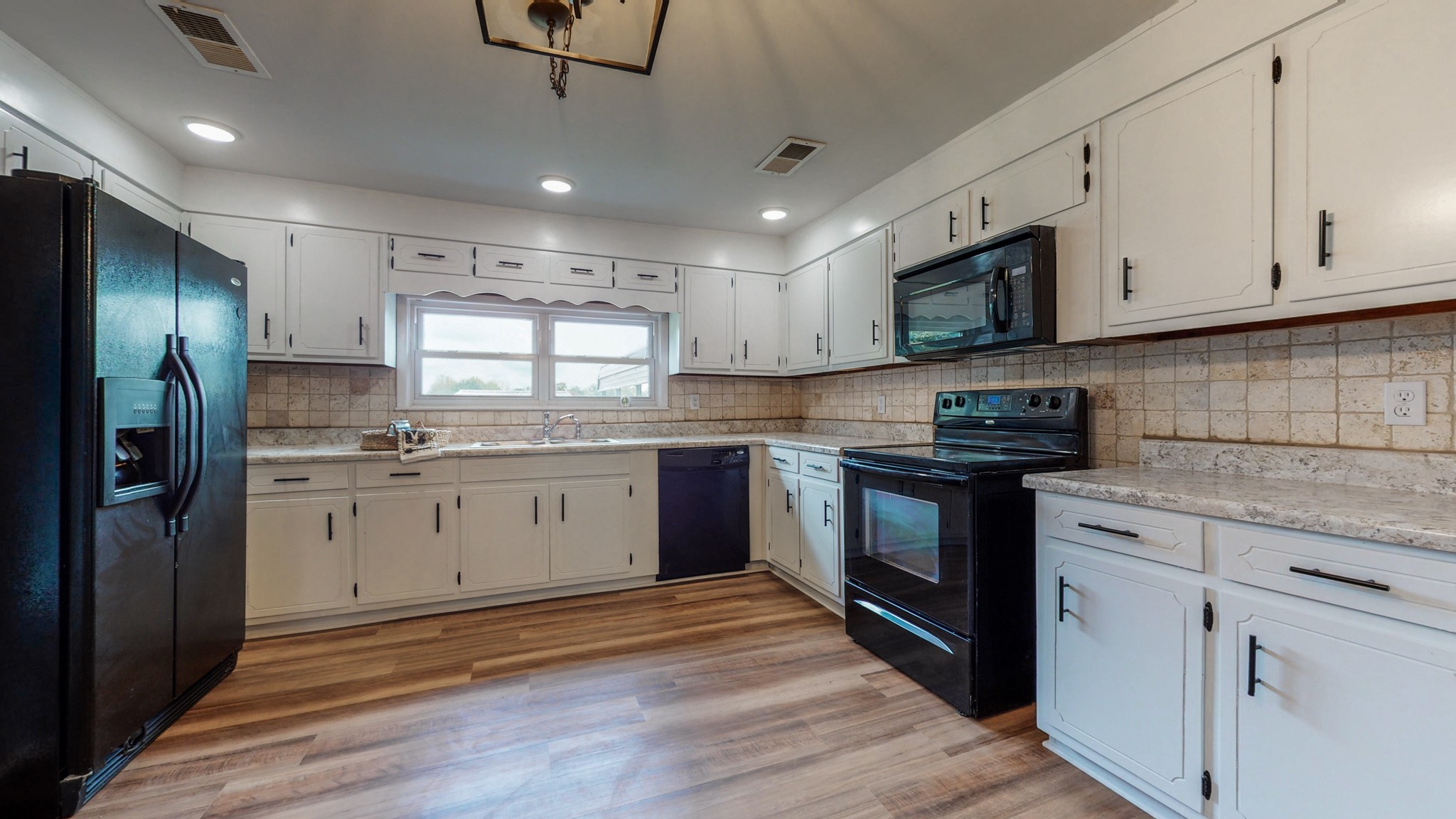 255 Limestone Road Elora, TN 37328 - Photo 5 of 45 a kitchen with stainless steel appliances granite countertop a refrigerator a sink dishwasher a stove and white countertops with wooden floor