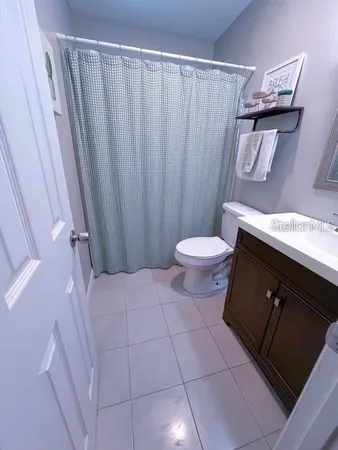 a bathroom with a granite countertop sink and a toilet