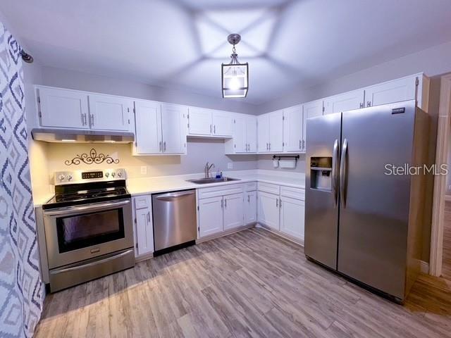 1928 Lawson Road Tallahassee, FL 32308 - Photo 8 of 20 a kitchen with stainless steel appliances a stove a sink dishwasher a refrigerator and a stove with wooden floor