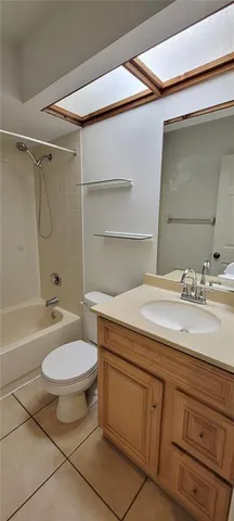 a bathroom with a granite countertop sink toilet a mirror and bathtub