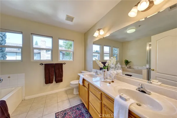 a bathroom with a double vanity sink a mirror and a bathtub