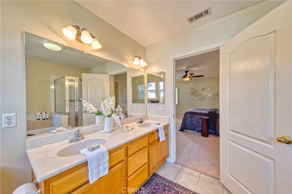 a spacious bathroom with a double vanity sink a mirror a bathtub and shower