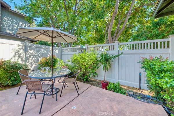 a patio with a table and chairs under an umbrella
