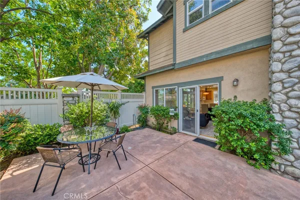 a view of a patio with furniture and a garden