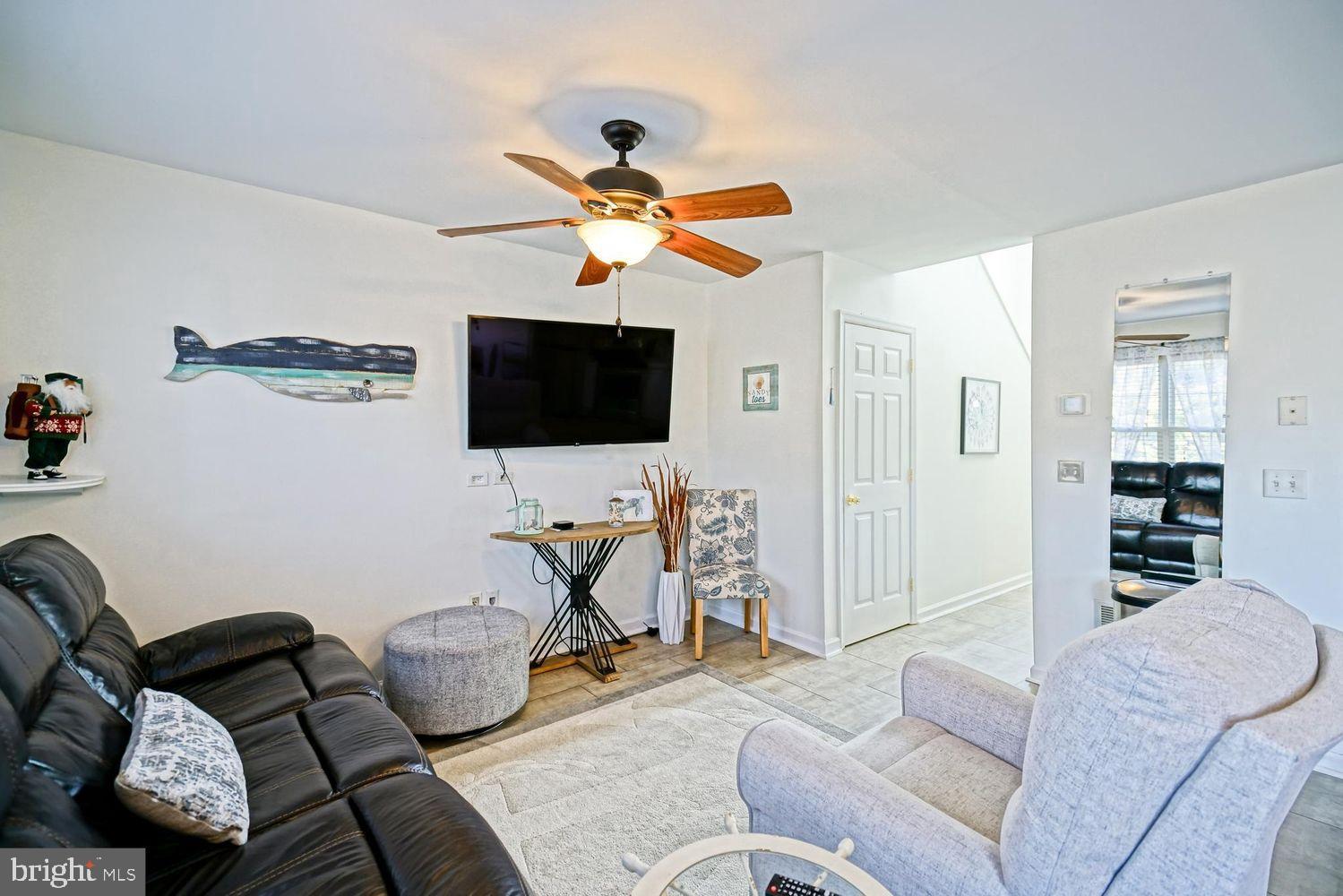 34531 Oakley Court, Unit 27 Lewes, DE 19958 - Photo 12 of 25 a living room with furniture and a flat screen tv