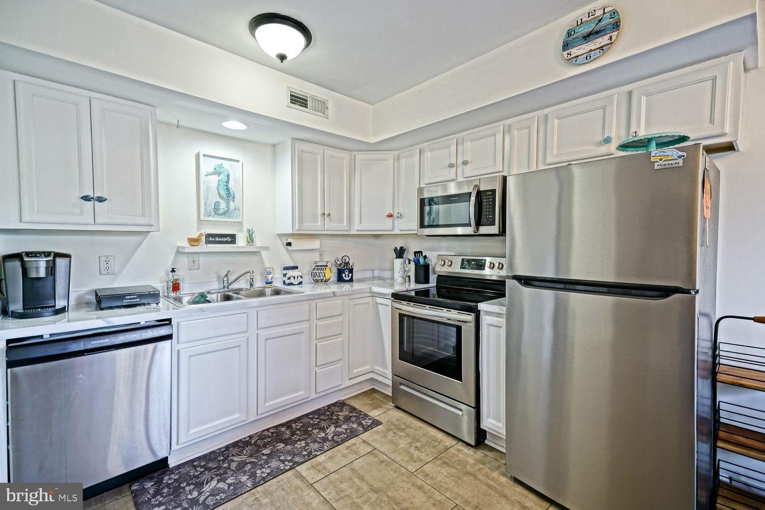 34531 Oakley Court, Unit 27 Lewes, DE 19958 - Photo 13 of 25 a kitchen with stainless steel appliances a refrigerator sink and microwave