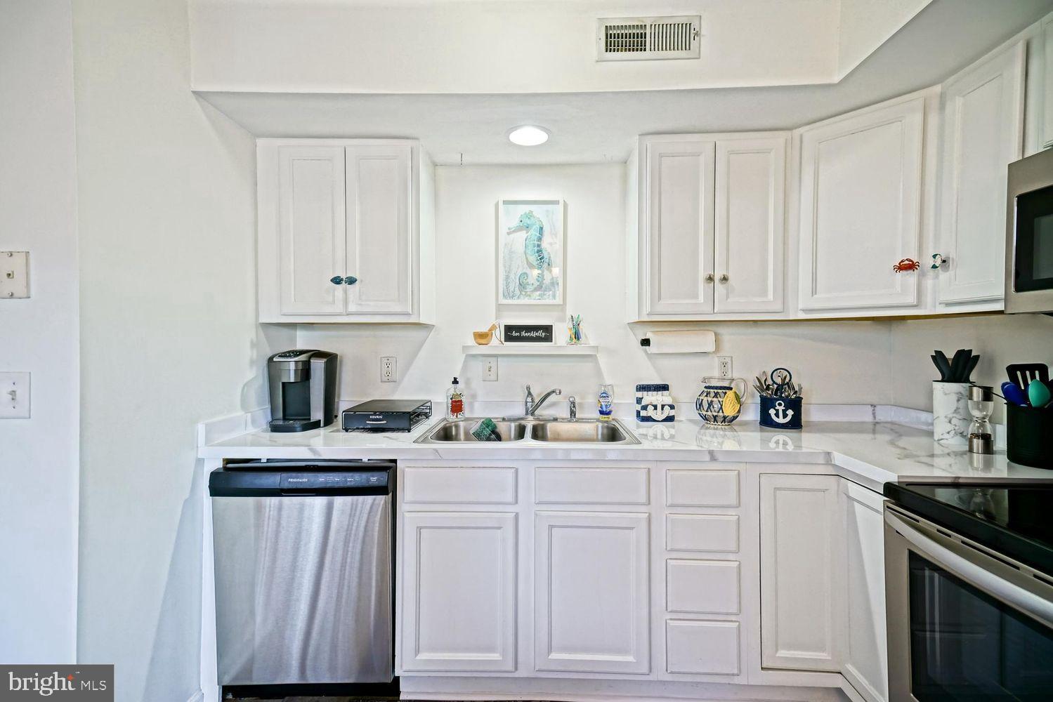 34531 Oakley Court, Unit 27 Lewes, DE 19958 - Photo 14 of 25 a kitchen with white cabinets and white appliances