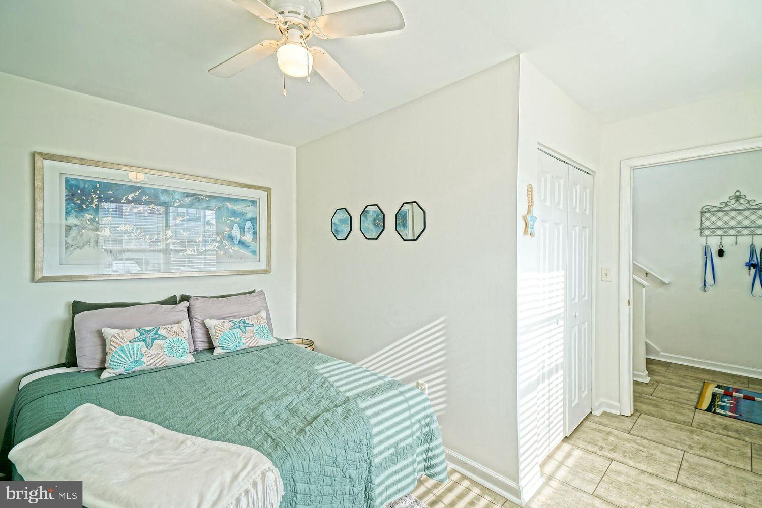34531 Oakley Court, Unit 27 Lewes, DE 19958 - Photo 5 of 25 a bedroom with a bed and a chandelier