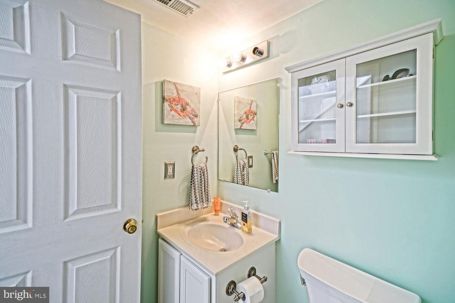 34531 Oakley Court, Unit 27 Lewes, DE 19958 - Photo 7 of 25 a bathroom with a toilet sink and mirror