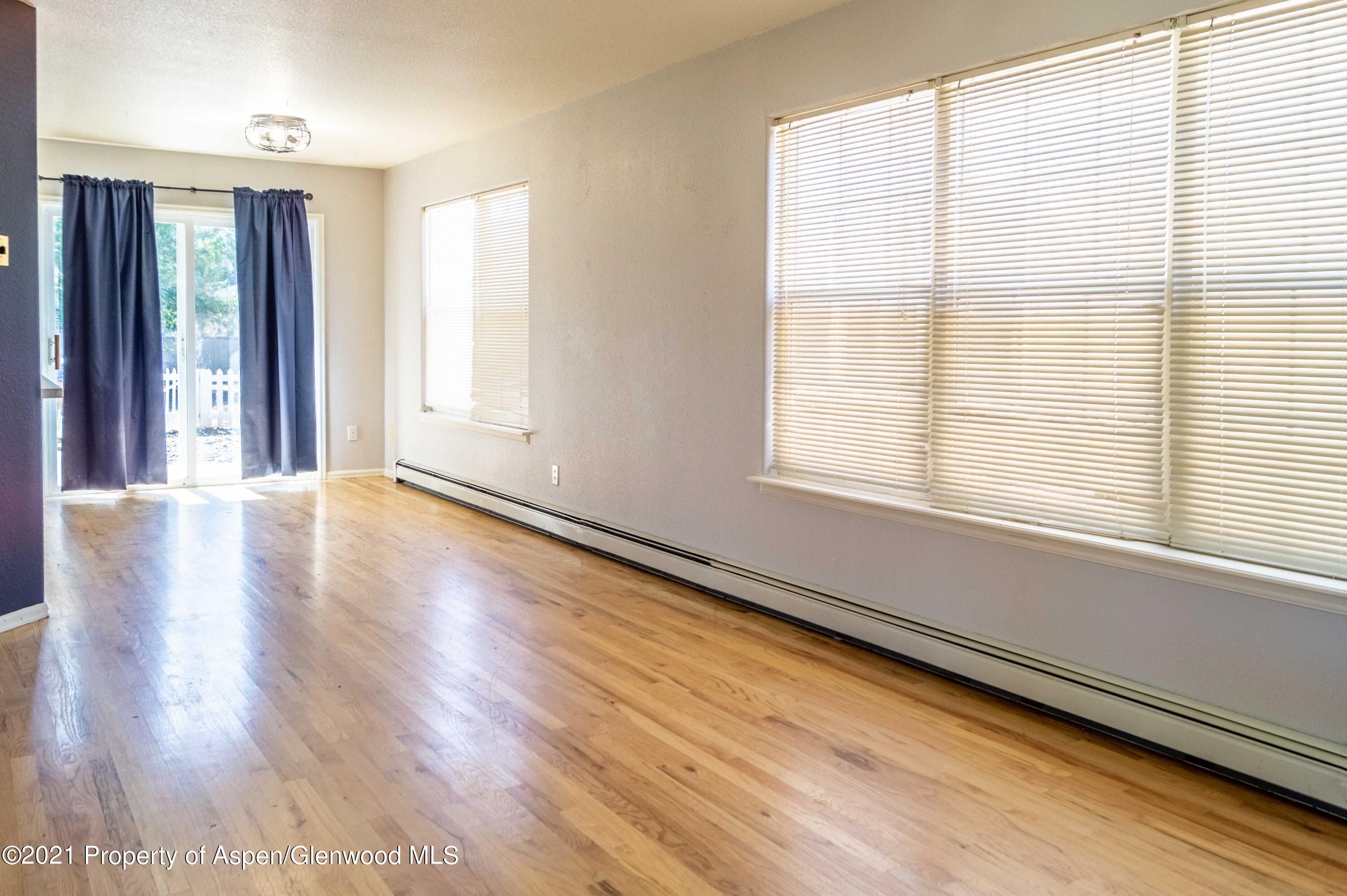 447 Columbine Drive Rifle, CO 81650 - Photo 12 of 36 a view of an empty room with wooden floor and a window