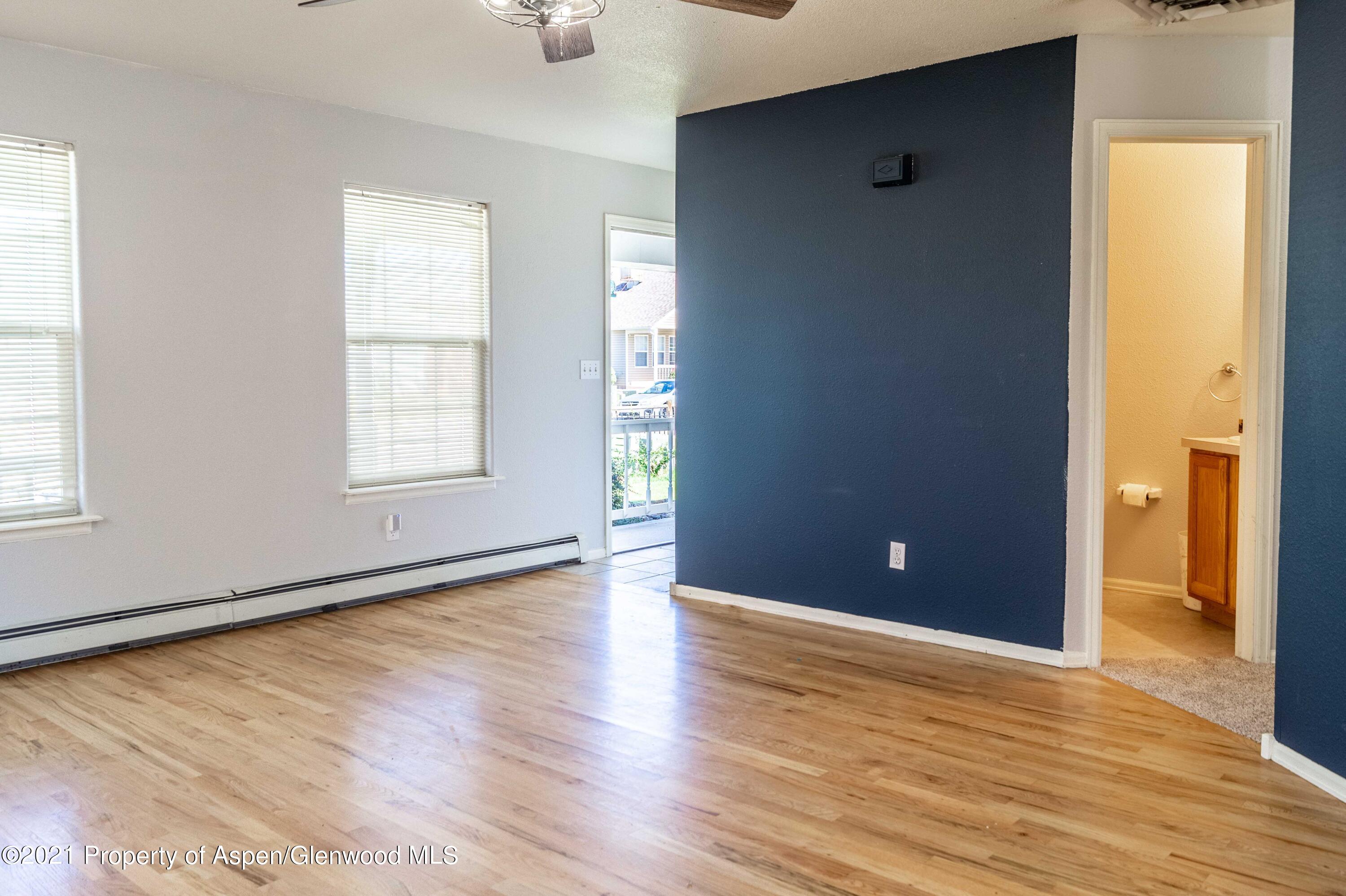 447 Columbine Drive Rifle, CO 81650 - Photo 13 of 36 an empty room with wooden floor and windows