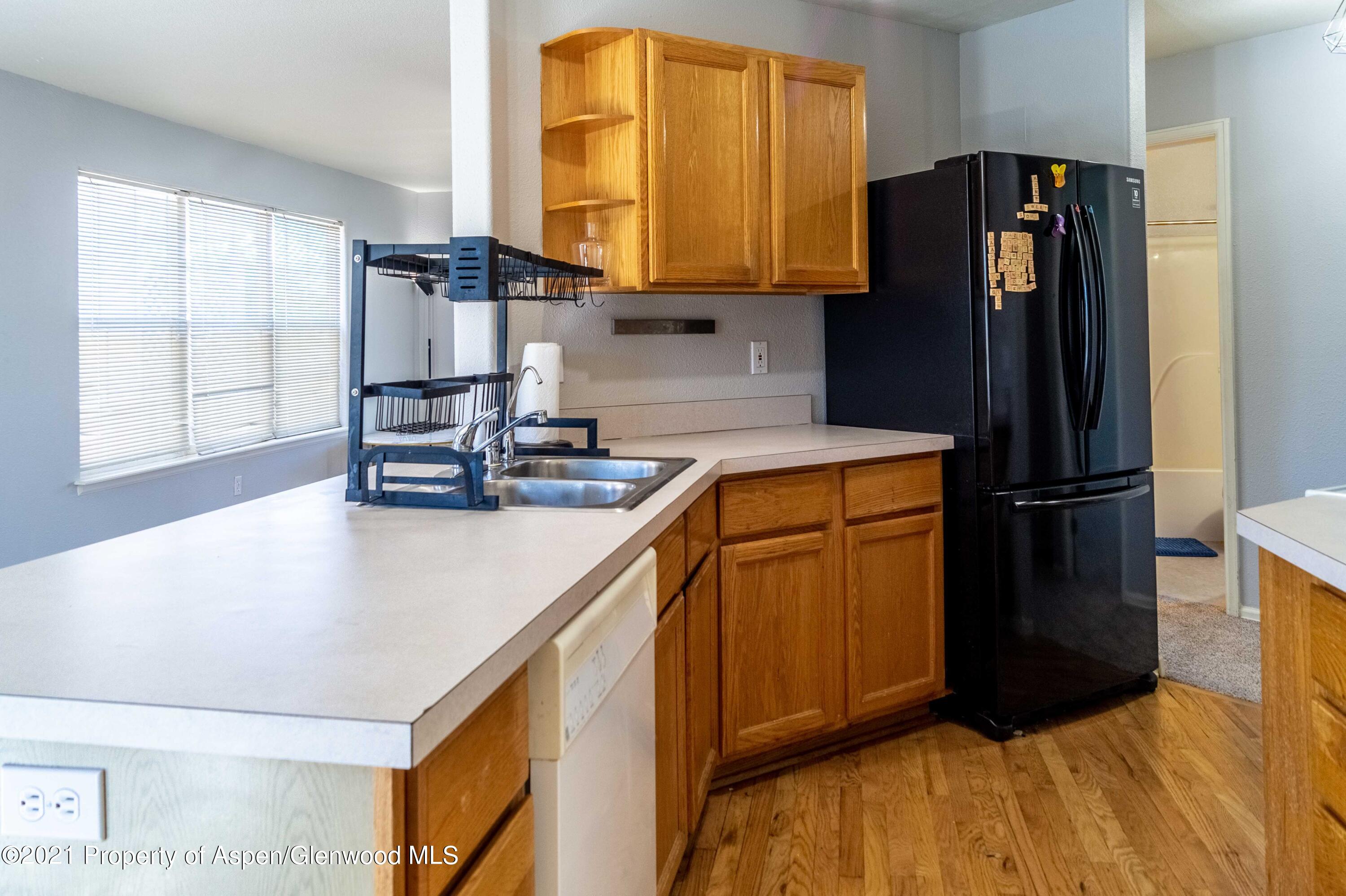447 Columbine Drive Rifle, CO 81650 - Photo 17 of 36 a kitchen with stainless steel appliances granite countertop a refrigerator a sink and a stove top oven