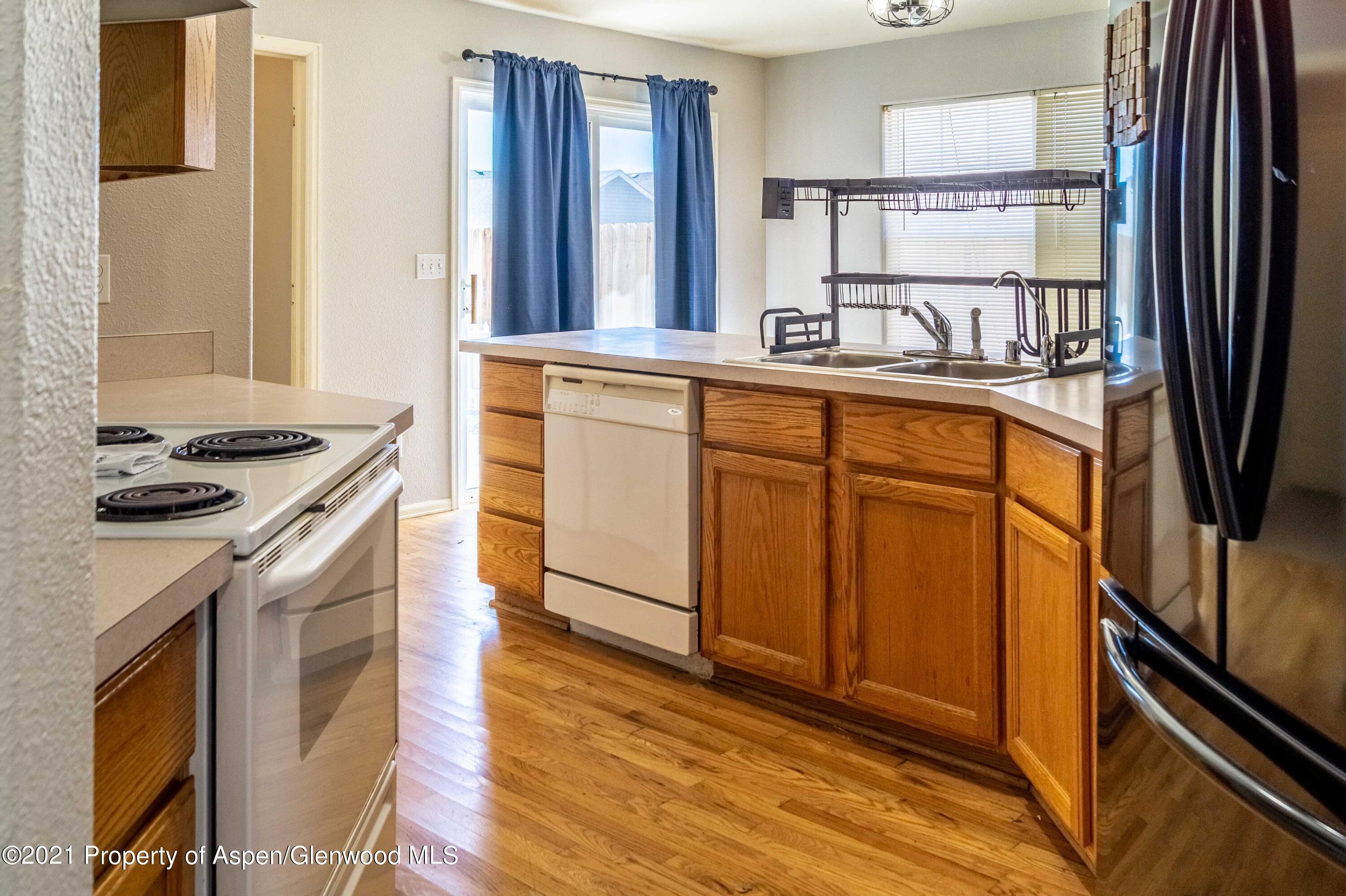 447 Columbine Drive Rifle, CO 81650 - Photo 18 of 36 a kitchen with stainless steel appliances granite countertop a stove a sink and a refrigerator