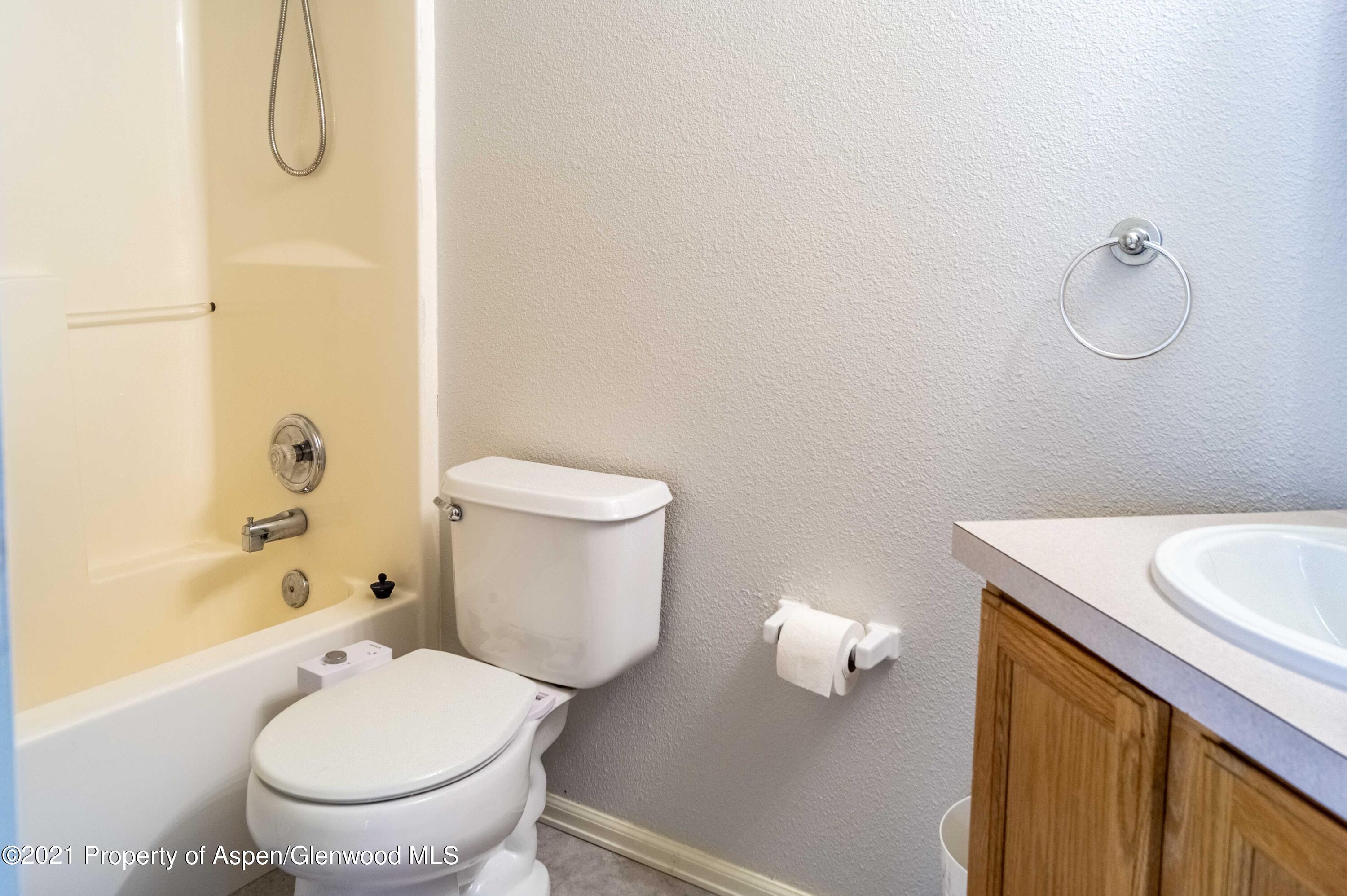 447 Columbine Drive Rifle, CO 81650 - Photo 29 of 36 a white toilet sitting next to a bathroom sink and a shower