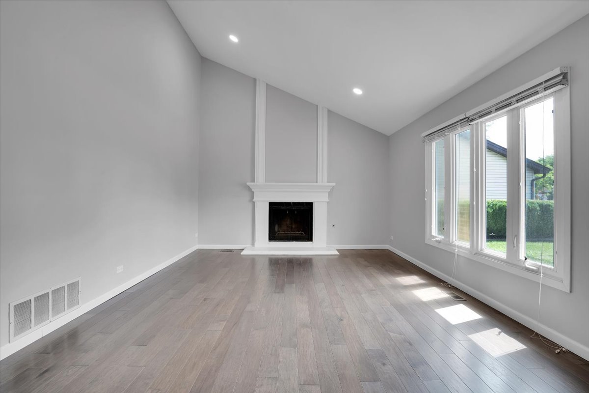 616 Rockhurst Road Bolingbrook, IL 60440 - Photo 5 of 37 a view of an empty room with wooden floor and a window