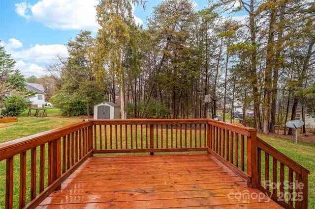 a view of deck and trees with wooden fence