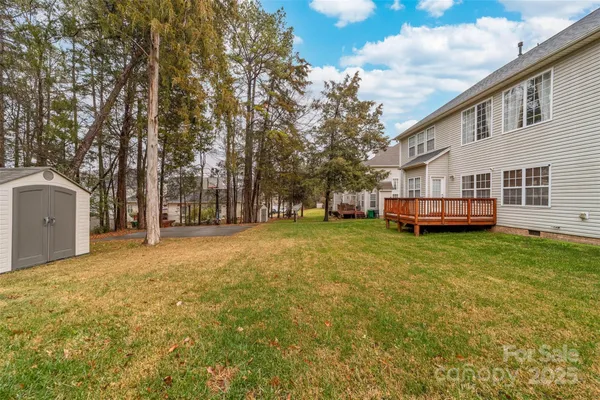 a view of a house with backyard and trees