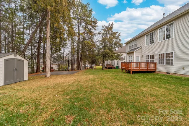 a view of a house with backyard and trees