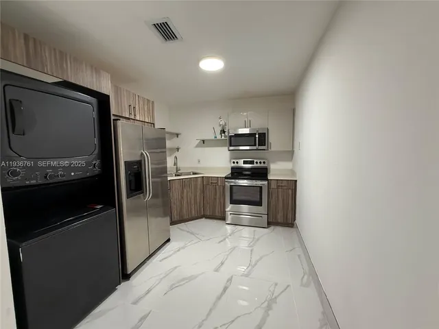 a kitchen with stainless steel appliances a refrigerator stove and microwave