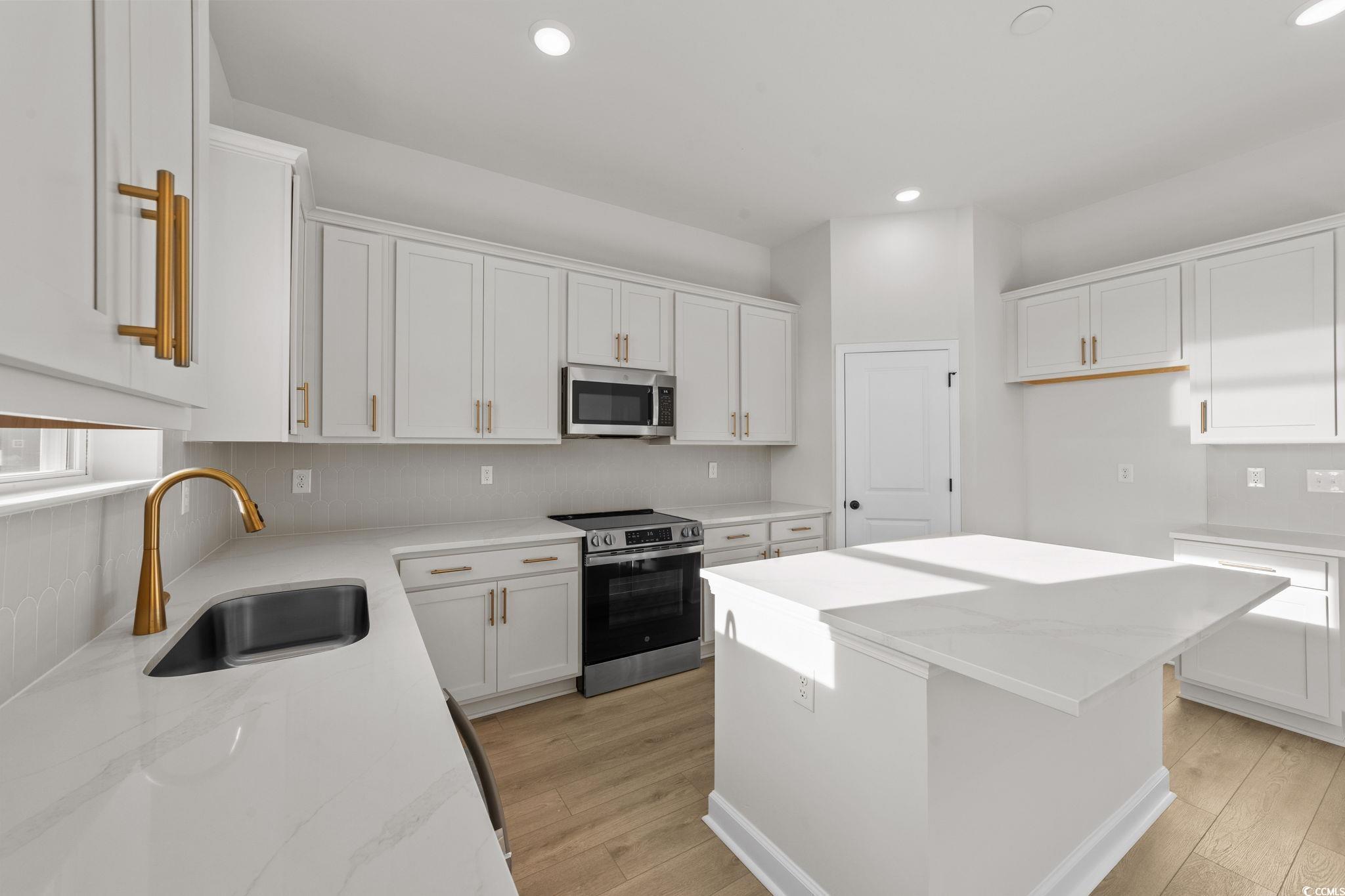 774 Ebb Tide Road Little River, SC 29566 - Photo 19 of 39 Kitchen with white cabinets, a center island, stainless steel appliances, recessed lighting, and light wood-style floors
